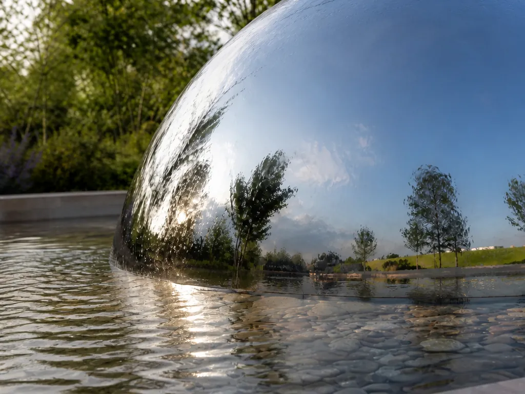 Close-up detail of the mirror-ball-garden-installation stainless steel sculpture showing its form and finish
